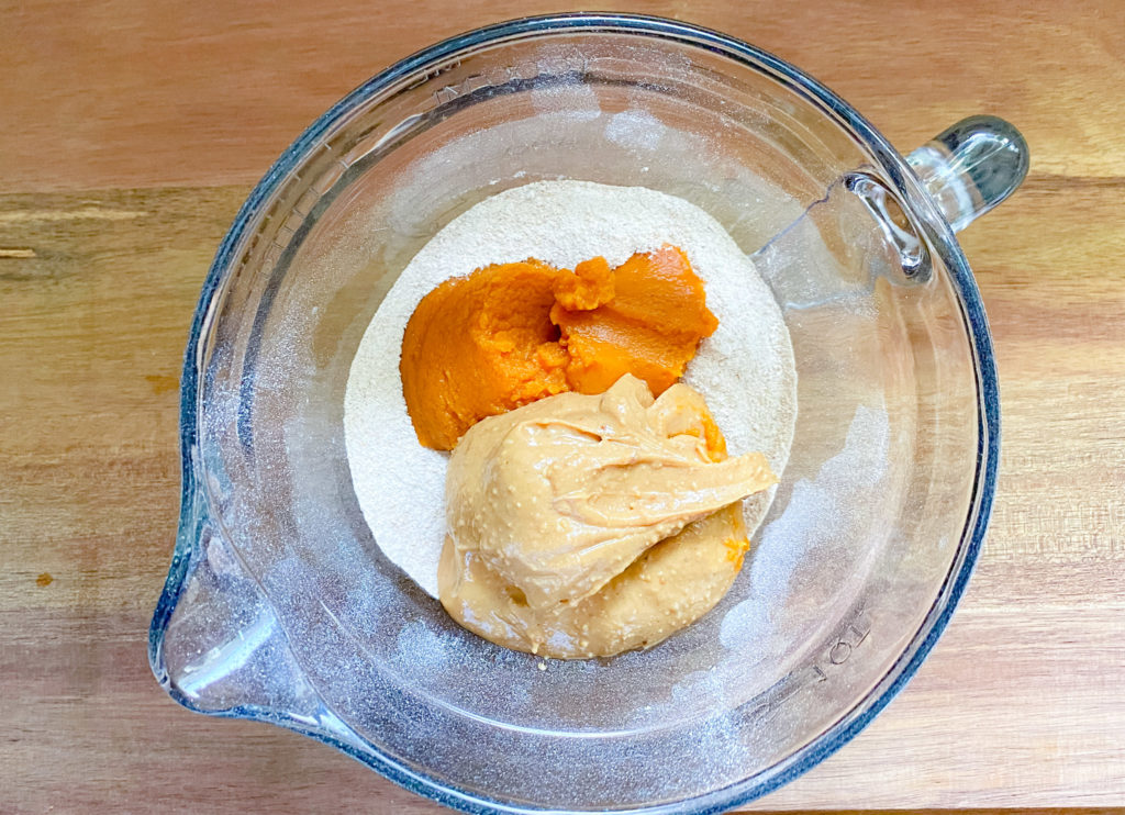 Peanut butter, pumpkin puree, and flour in a mixing bowl